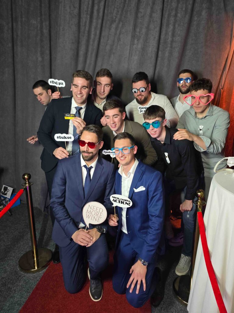 Društvo na crvenom tepihu u foto kutku